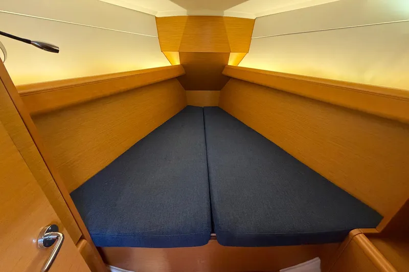 Layover Yacht Photos Pics Cozy cabin interior of 2018 Jeanneau Sun Odyssey 389 sailboat with blue cushions.