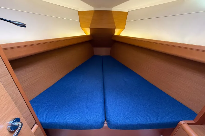 Layover Yacht Photos Pics Cozy cabin interior of 2018 Jeanneau Sun Odyssey 389 with blue cushions.