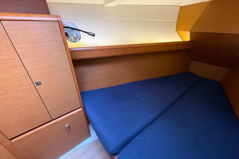Layover Yacht Photos Pics Cozy cabin interior of 2018 Jeanneau Sun Odyssey 389 sailboat with blue bedding.