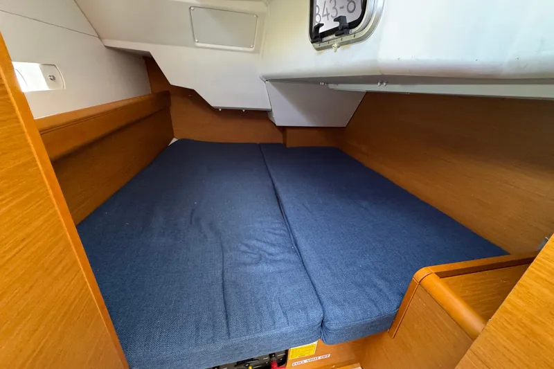 Layover Yacht Photos Pics Cozy cabin interior of 2018 Jeanneau Sun Odyssey 389 sailboat with blue bedding.