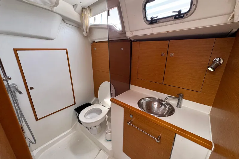 Layover Yacht Photos Pics 2018 Jeanneau Sun Odyssey 389 bathroom with sink, toilet, and wooden cabinetry.