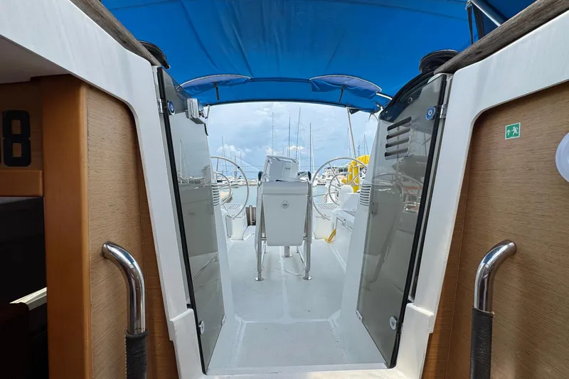 Layover Yacht Photos Pics 2018 Jeanneau Sun Odyssey 389 cockpit with blue canopy and dual steering wheels.