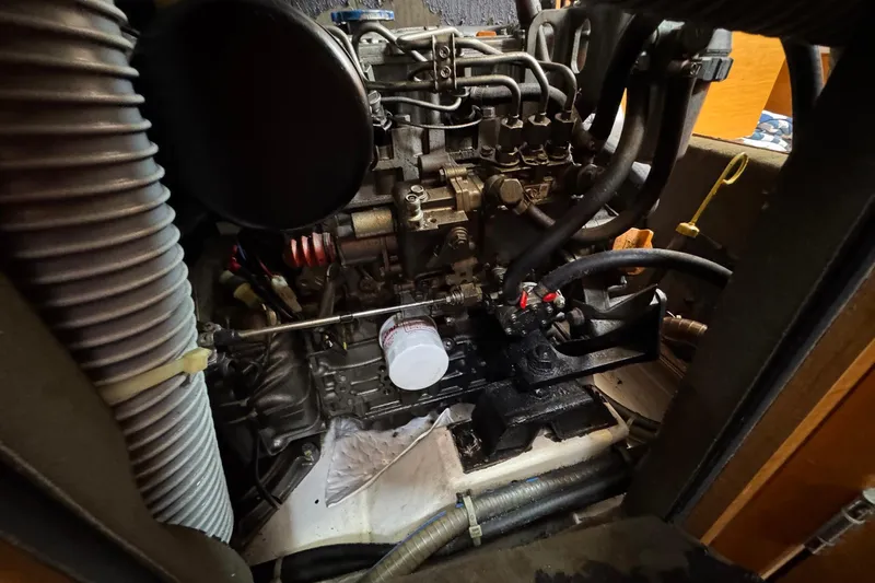 Layover Yacht Photos Pics Engine compartment of 2018 Jeanneau Sun Odyssey 389 sailboat, showcasing mechanical components and hoses.