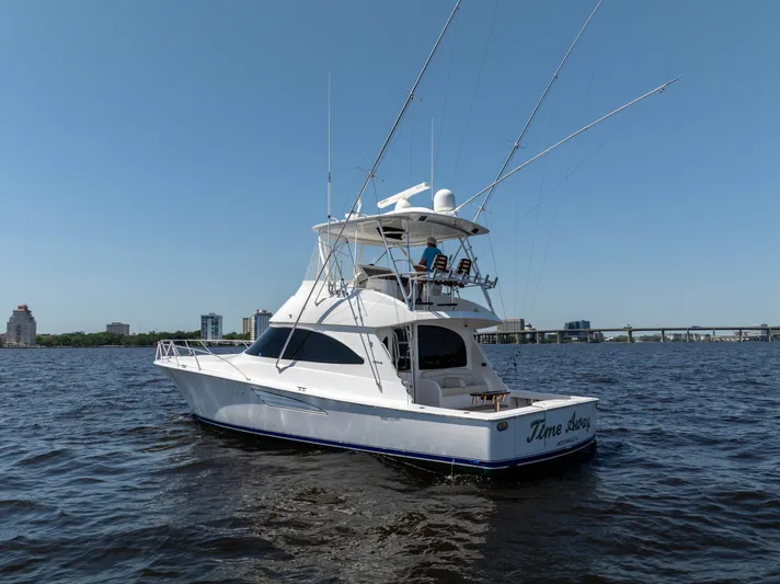Time Away Yacht Photos Pics 2019 Viking 48 Convertible yacht on open water, clear sky, cityscape background.