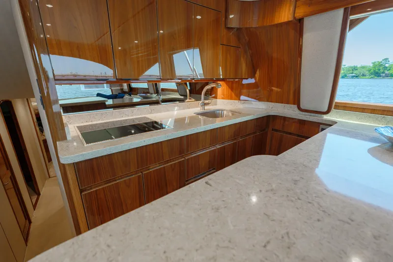 Time Away Yacht Photos Pics Luxurious kitchen interior of 2019 Viking 48 Convertible yacht with modern wood cabinetry and countertops.