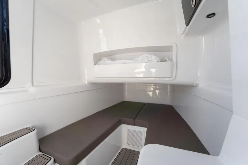  Yacht Photos Pics 2024 Yellowfin 42 Offshore cabin interior with cushioned seating and storage.