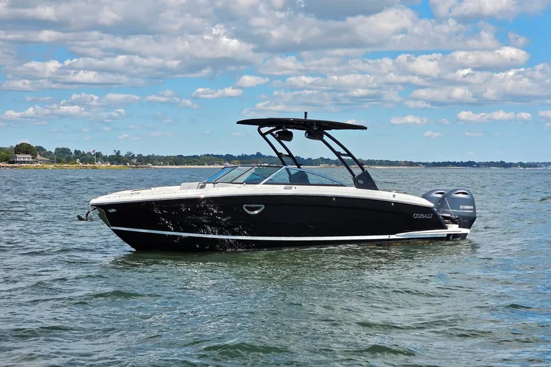  Yacht Photos Pics 2024 Cobalt R8 Outboard boat on calm water under a partly cloudy sky.