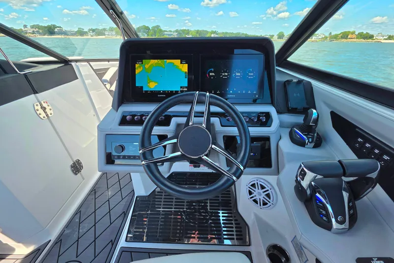  Yacht Photos Pics 2024 Cobalt R8 Outboard helm with advanced navigation displays and controls, overlooking serene waters.