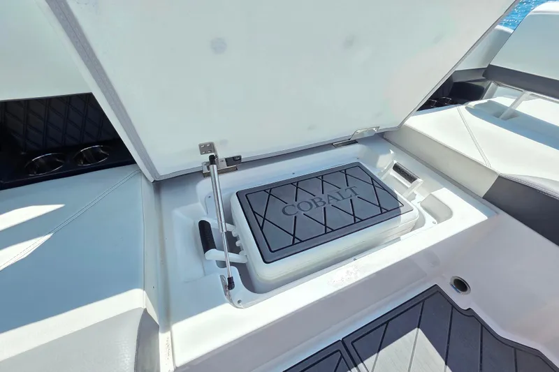  Yacht Photos Pics 2024 Cobalt R8 Outboard boat storage compartment with open lid, showcasing interior design.