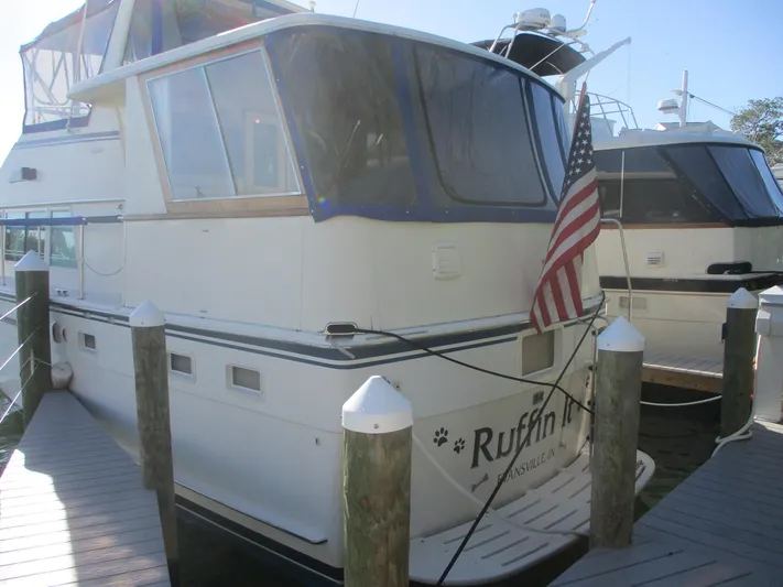  Yacht Photos Pics 1986 Hatteras 43 Double Cabin yacht docked with American flag displayed.