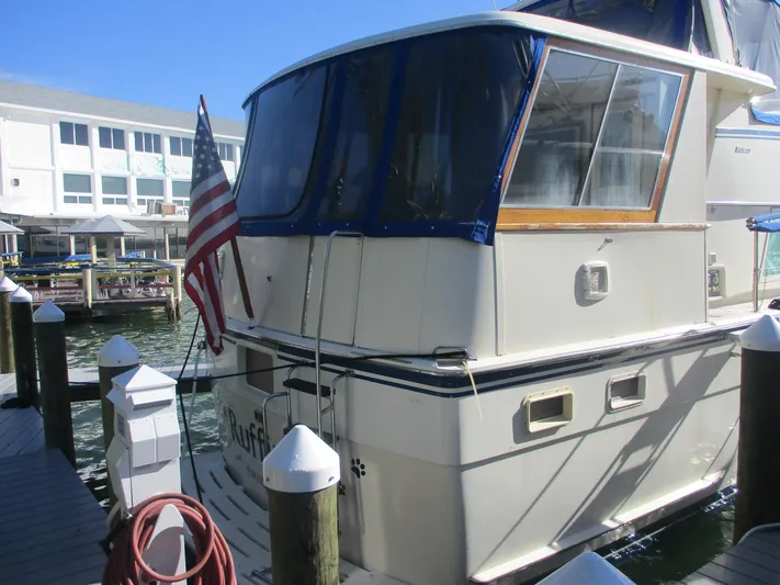  Yacht Photos Pics 1986 Hatteras 43 Double Cabin yacht docked with American flag, sunny day.