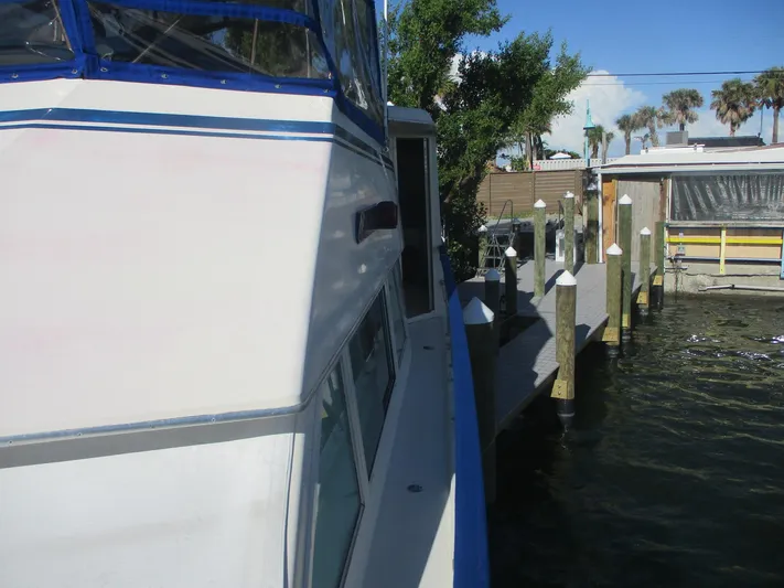  Yacht Photos Pics 1986 Hatteras 43 Double Cabin yacht docked beside a wooden pier.