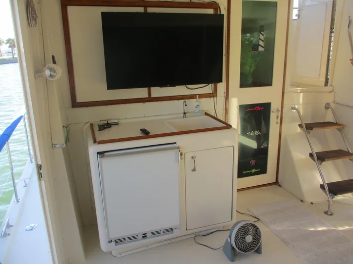  Yacht Photos Pics 1986 Hatteras 43 Double Cabin interior with TV, mini fridge, and stairs.