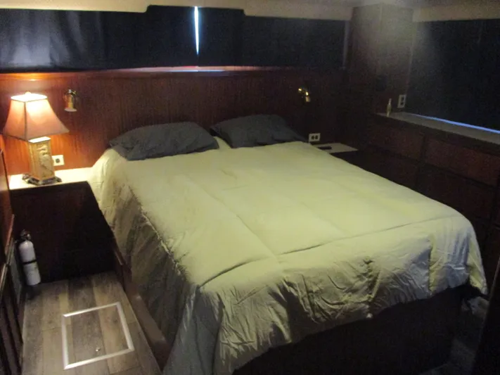  Yacht Photos Pics Cozy bedroom in 1986 Hatteras 43 Double Cabin yacht with wood paneling and soft lighting.
