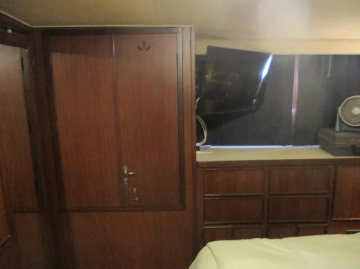  Yacht Photos Pics Interior of 1986 Hatteras 43 Double Cabin with wood paneling and mounted TV.