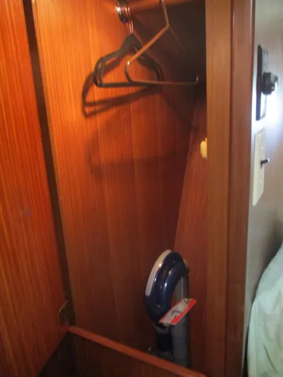  Yacht Photos Pics Wooden closet interior on 1986 Hatteras 43 Double Cabin with hangers and vacuum cleaner.