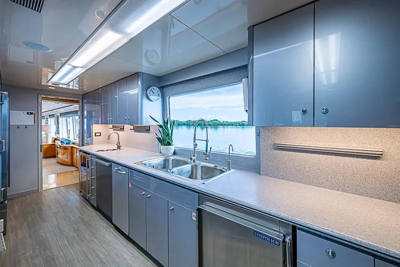 Probability Yacht Photos Pics Modern yacht kitchen interior with sleek cabinetry, large window view, and stainless steel appliances, Delta Marine 1997.