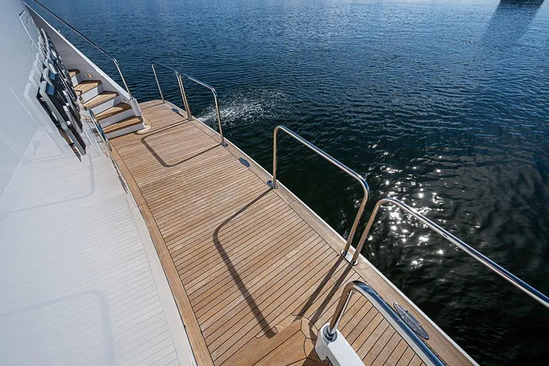 Probability Yacht Photos Pics Teak deck of 1997 Delta Marine yacht with stainless steel railings over water.