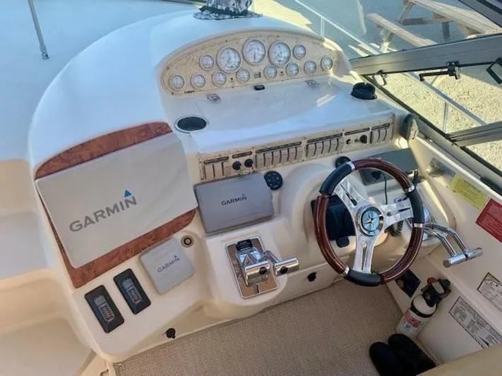  Yacht Photos Pics 1998 Cruisers Yachts 3870 Express helm with Garmin navigation and classic wood-accented steering wheel.