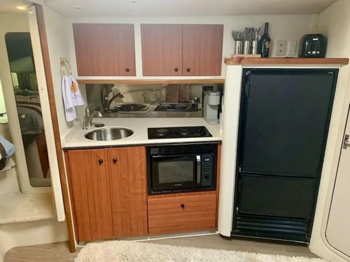  Yacht Photos Pics 1998 Cruisers Yachts 3870 Express kitchen with wood cabinets, sink, stove, and refrigerator.