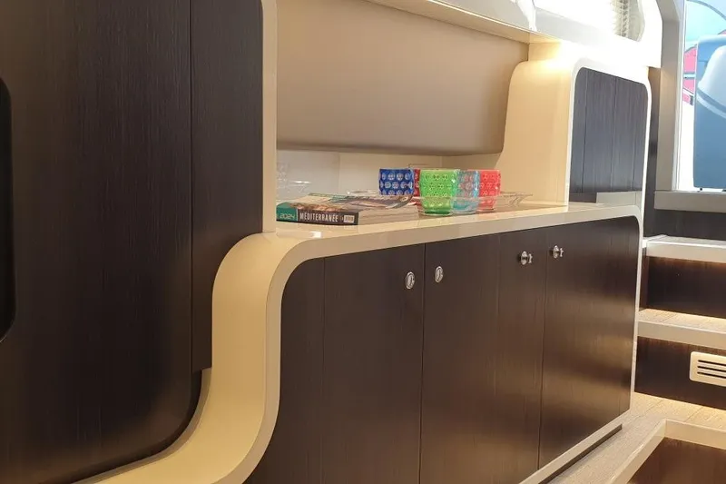 Malola Yacht Photos Pics Interior of 2022 Canados Gladiator 431 WA yacht with modern cabinetry and colorful glassware.