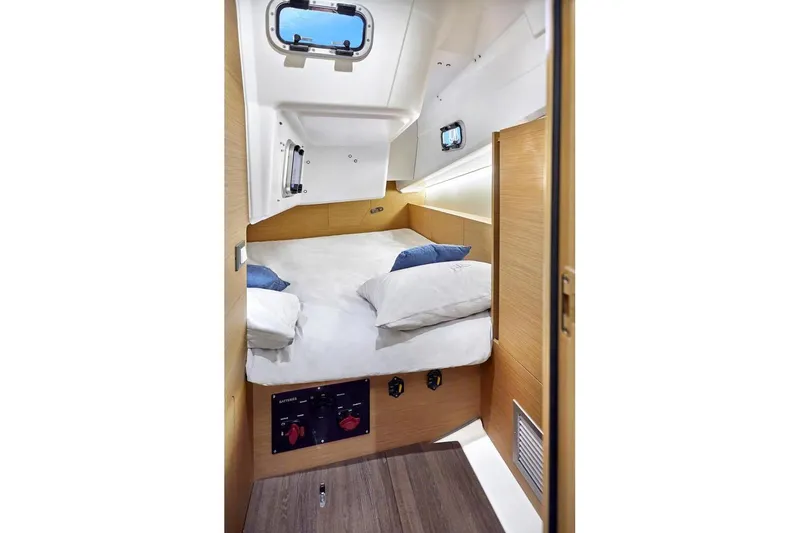  Yacht Photos Pics Cozy cabin interior of 2022 Jeanneau Sun Odyssey 380 sailboat with bed and porthole.
