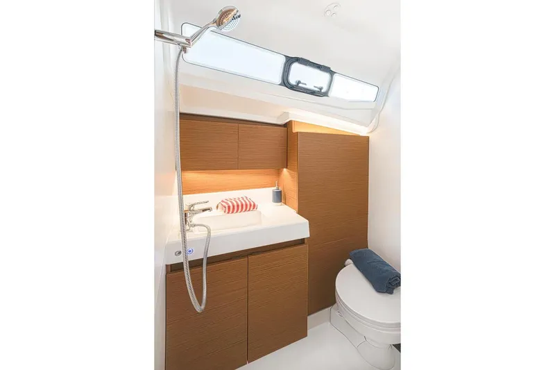  Yacht Photos Pics Modern bathroom in 2022 Jeanneau Sun Odyssey 380 yacht with wooden cabinets and sleek fixtures.