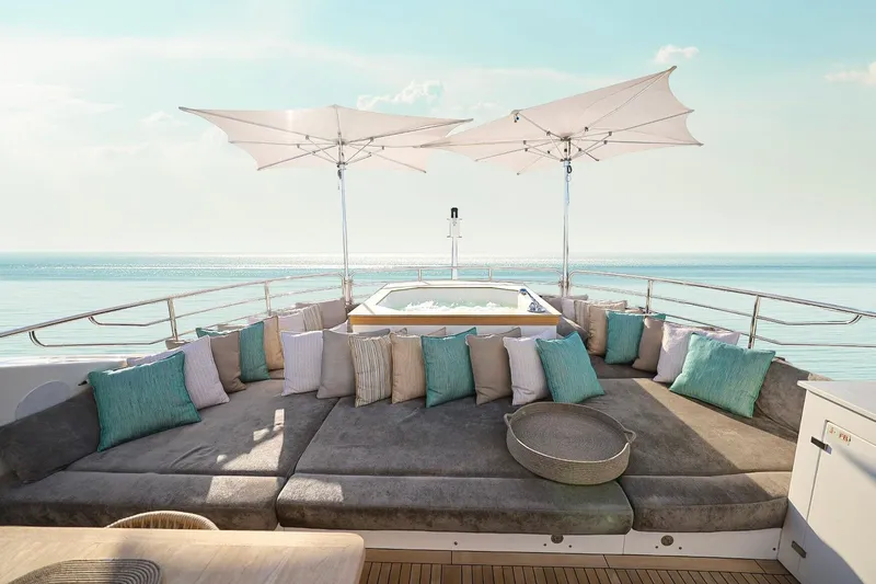 Marin Yacht Photos Pics Luxurious Sunseeker 131 yacht deck with plush seating, cushions, and parasols, overlooking serene ocean.