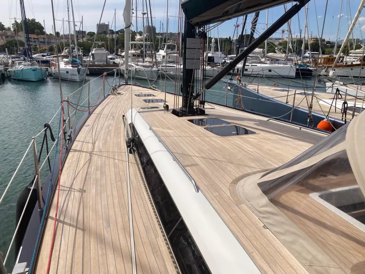  Yacht Photos Pics Luxurious 2022 Solaris 55 yacht docked at marina, showcasing sleek wooden deck design.