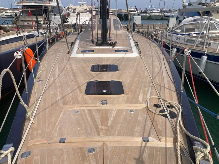  Yacht Photos Pics 2022 Solaris 55 yacht deck with sleek wooden finish, docked in a marina.