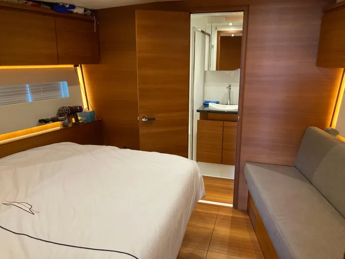  Yacht Photos Pics Luxurious interior of 2022 Solaris 55 yacht featuring bedroom and bathroom with wooden finishes.