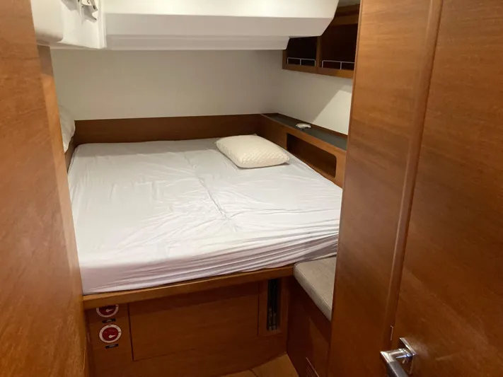  Yacht Photos Pics Cozy cabin interior of 2022 Solaris 55 yacht with wooden finish and comfortable bedding.
