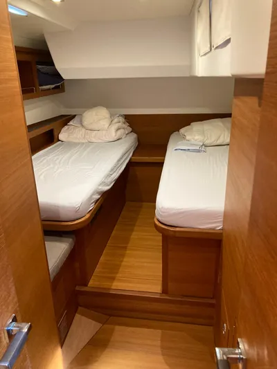  Yacht Photos Pics 2022 Solaris 55 yacht cabin with twin beds and wooden interior.