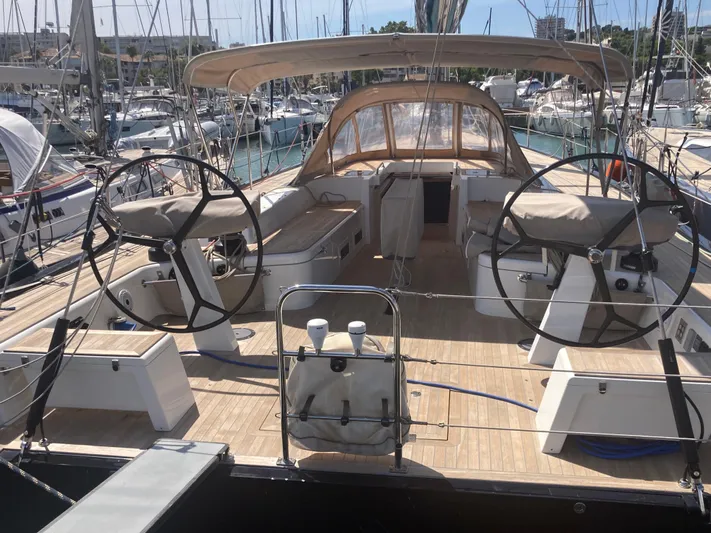  Yacht Photos Pics 2022 Solaris 55 yacht cockpit with dual steering wheels and spacious seating at marina.