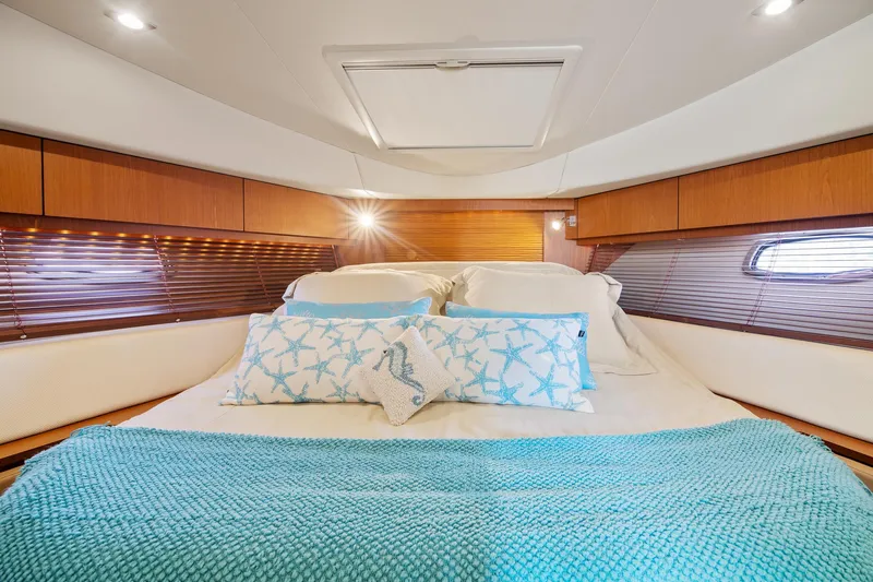  Yacht Photos Pics Luxurious cabin interior of 2013 Sea Ray 410 Sundancer with cozy bedding and elegant wood finish.