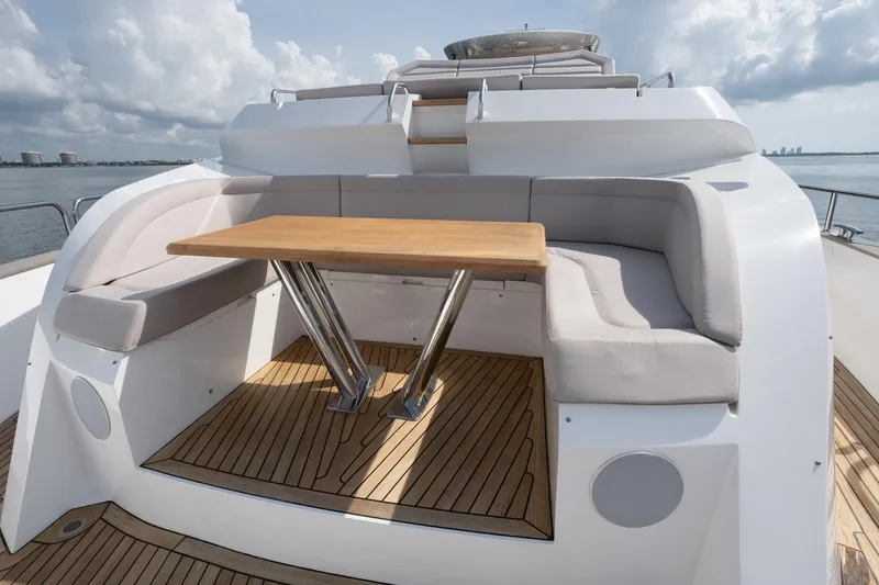 Eos Yacht Photos Pics Sunseeker 95 Yacht 2021, outdoor seating area with wooden table and cushioned seats.