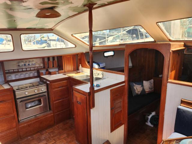 1978 Hardin Voyager 44 yacht interior with wooden cabinetry and cozy seating area.