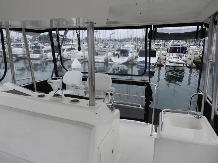  Yacht Photos Pics 1998 Riviera Convertible yacht interior with marina view, featuring helm and seating area.