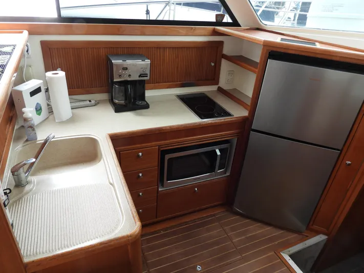  Yacht Photos Pics 1998 Riviera Convertible yacht kitchen with sink, coffee maker, microwave, and stainless steel fridge.