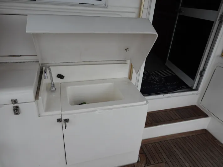  Yacht Photos Pics 1998 Riviera Convertible boat sink with open lid, adjacent to cabin entrance.