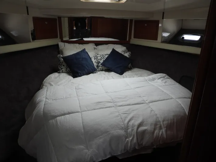  Yacht Photos Pics 1998 Riviera Convertible cabin with cozy bed, white bedding, and decorative pillows.