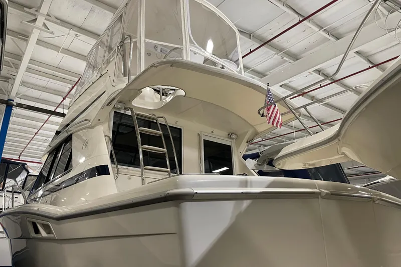  Yacht Photos Pics 2002 Riviera 34 Convertible yacht in indoor storage, featuring sleek design and American flag.