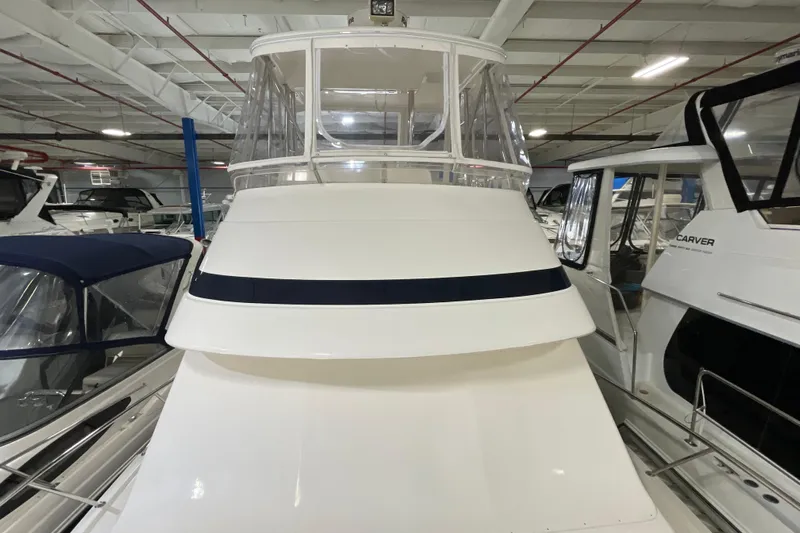  Yacht Photos Pics 2002 Riviera 34 Convertible yacht in indoor storage, surrounded by other boats.