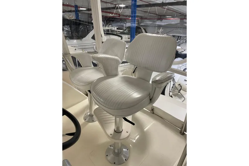  Yacht Photos Pics Captain's chairs on 2002 Riviera 34 Convertible yacht, featuring sleek white upholstery.