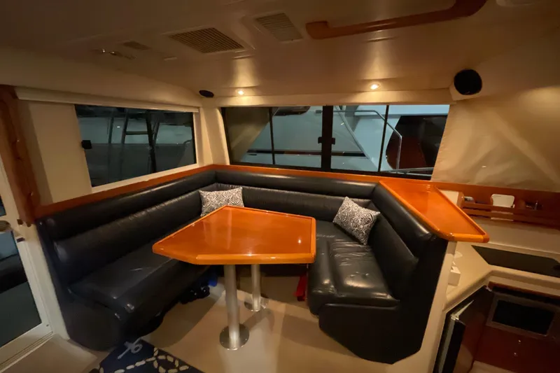  Yacht Photos Pics Luxurious interior of 2002 Riviera 34 Convertible yacht with elegant seating and wooden table.