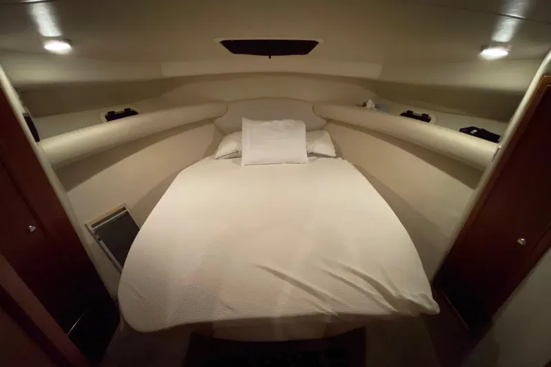  Yacht Photos Pics Cozy bedroom interior of 2002 Riviera 34 Convertible yacht with soft lighting.