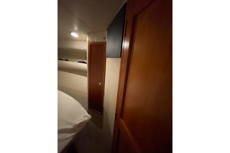  Yacht Photos Pics Interior cabin of 2002 Riviera 34 Convertible yacht with wooden door and cozy lighting.