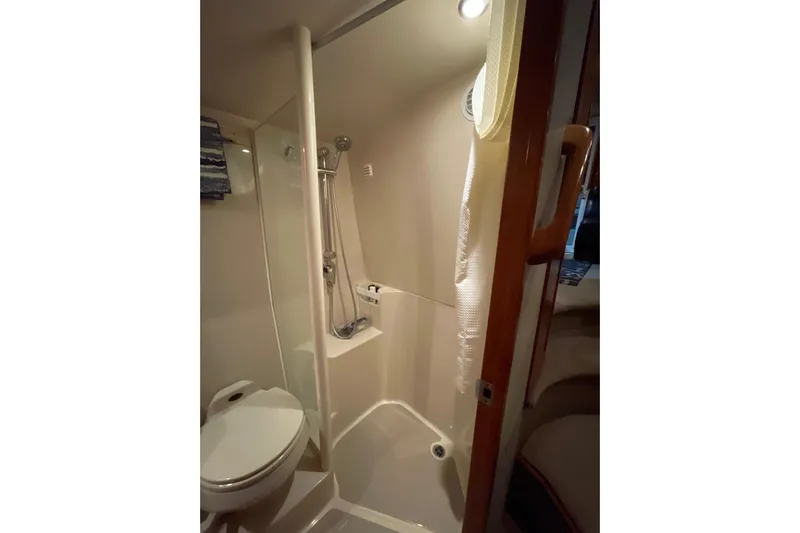  Yacht Photos Pics Compact bathroom in a 2002 Riviera 34 Convertible yacht, featuring a shower and toilet.