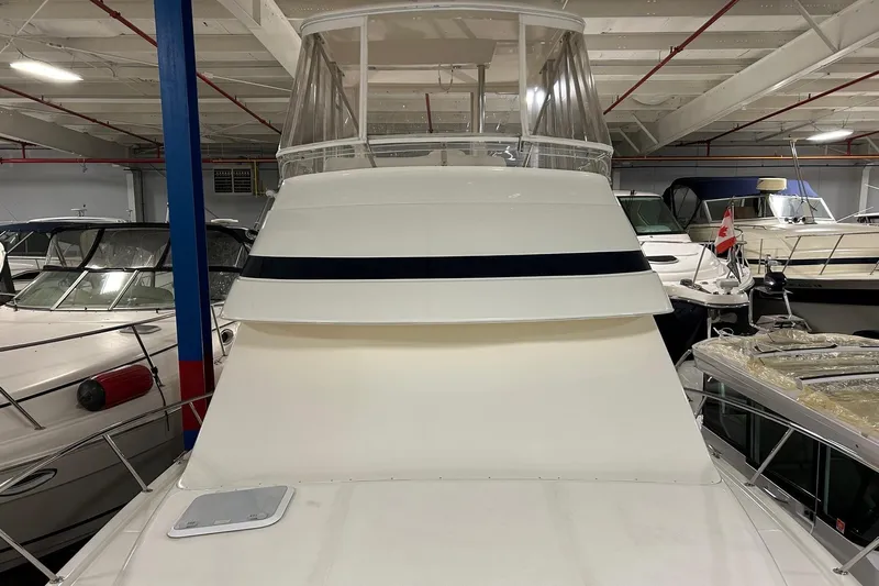  Yacht Photos Pics 2002 Riviera 34 Convertible yacht in indoor storage, surrounded by other boats.