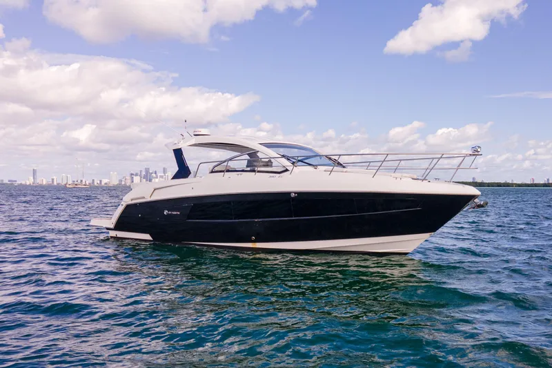  Yacht Photos Pics 2018 Cruisers Yachts 390 Express Coupe on open water with city skyline backdrop.